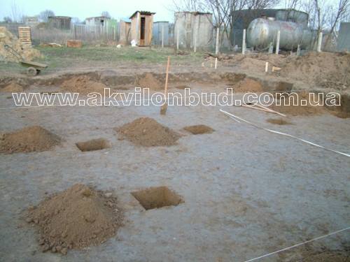 будівництво дачного будинку. Майданчик з ямами під стовпи
