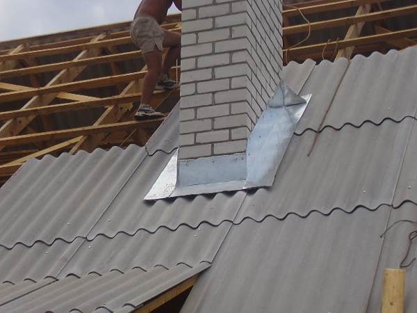 Дім із дерев'яною структурою. Нижня примикання труби до покрівлі.