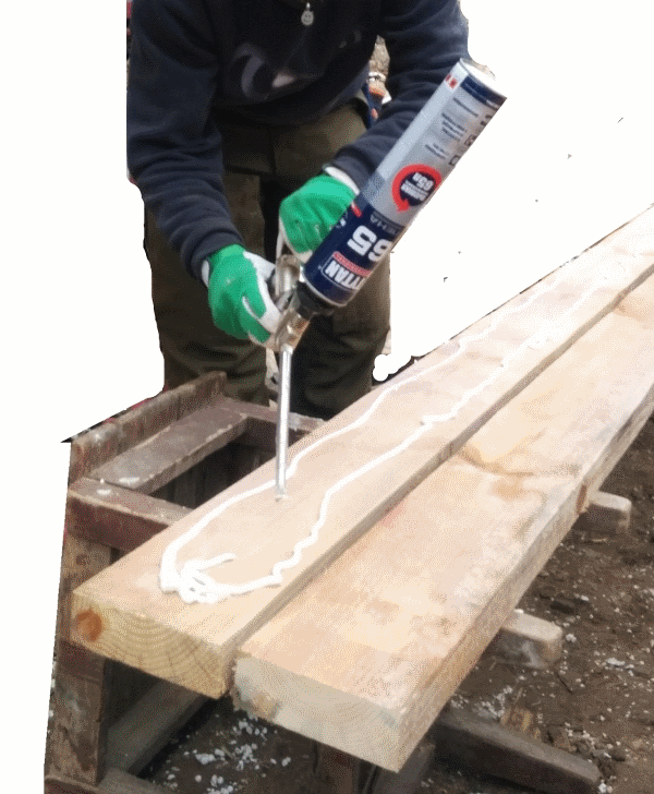 Нанесення герметика на дерев'яну балку